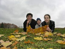 Lächelngesichter der Familie auf Herbstblättern Lächelngesichter der Familie auf Herbstblättern