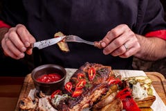 Läckra grillade stöd kryddade med nya örter, kålsallad, drog tillbaka potatisen på en gammal lantlig träskärbräda arkivbilder Läckra grillade stöd kryddade med nya örter, kålsallad, drog tillbaka potatisen på en gammal lantlig träskärbräda arkivbilder