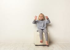 Läskig stående för gullig lycklig liten flicka i studio arkivfoto Läskig stående för gullig lycklig liten flicka i studio arkivfoto