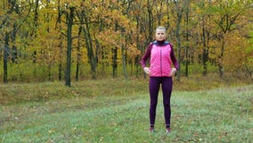 långsam rörelse Härlig konditionsportflicka i sportsweardrinkvatten eller isotonic drink från en sportvattenflaska i hösten arkivfilmer långsam rörelse Härlig konditionsportflicka i sportsweardrinkvatten eller isotonic drink från en sportvattenflaska i hösten arkivfilmer