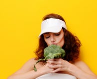 Légume vert frais de brocoli de morsure de jeune femme grand dans le chapeau blanc photos stock Légume vert frais de brocoli de morsure de jeune femme grand dans le chapeau blanc photos stock