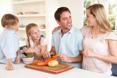 Légumes heureux d'écaillement de famille dans la cuisine images libres de droits Légumes heureux d'écaillement de famille dans la cuisine images libres de droits