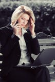 Młoda biznesowa kobieta dzwoni na telefonie komórkowym z laptopem Obraz Royalty Free Młoda biznesowa kobieta dzwoni na telefonie komórkowym z laptopem Obraz Royalty Free