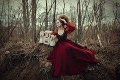 Młoda dziewczyna pozuje w czerwonej sukni z kreatywnie fryzurą fotografia stock Młoda dziewczyna pozuje w czerwonej sukni z kreatywnie fryzurą fotografia stock