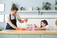 M?oda szcz??liwa para ma zabaw? podczas gdy robi? czy?ci? w domu obraz stock M?oda szcz??liwa para ma zabaw? podczas gdy robi? czy?ci? w domu obraz stock