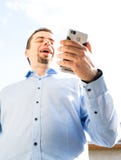M?ody biznesowy m??czyzna u?ywa telefon kom?rkowy ?mia si? i pisa? na maszynie wiadomo?? zdjęcia royalty free M?ody biznesowy m??czyzna u?ywa telefon kom?rkowy ?mia si? i pisa? na maszynie wiadomo?? zdjęcia royalty free