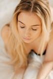 Ma?ana feliz Mujer rubia joven bonita sonriente que se relaja en la cama blanca imagen de archivo Ma?ana feliz Mujer rubia joven bonita sonriente que se relaja en la cama blanca imagen de archivo