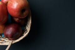Ma??s vermelhas maduras em uma cesta em um fundo escuro imagem de stock Ma??s vermelhas maduras em uma cesta em um fundo escuro imagem de stock