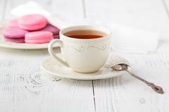 Macarons et tasse français colorés de thé sur un dos en bois rustique photos stock Macarons et tasse français colorés de thé sur un dos en bois rustique photos stock