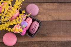 Macarons franceses dulces en un paquete con las flores y la mimosa fotografía de archivo libre de regalías Macarons franceses dulces en un paquete con las flores y la mimosa fotografía de archivo libre de regalías