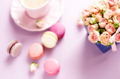 Macaroons в пастельных цветах с букетом розовых роз цветут Стоковое Изображение RF Macaroons в пастельных цветах с букетом розовых роз цветут Стоковое Изображение RF