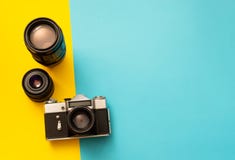 Macchina fotografica della foto con le lenti di riserva su fondo blu e giallo fotografia stock Macchina fotografica della foto con le lenti di riserva su fondo blu e giallo fotografia stock