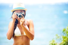 Macchina fotografica della tenuta della donna della spiaggia di estate che cattura maschera fotografia stock libera da diritti Macchina fotografica della tenuta della donna della spiaggia di estate che cattura maschera fotografia stock libera da diritti