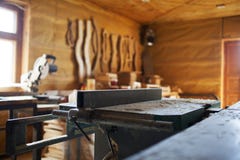 Macchina per la lavorazione del legno in un'officina privata fotografia stock Macchina per la lavorazione del legno in un'officina privata fotografia stock