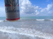 MACEIO, AL BRAZYLIA, Maj, - 12, 2019: Budweiser zimny piwo, piękny morze za i niebo i fotografia stock MACEIO, AL BRAZYLIA, Maj, - 12, 2019: Budweiser zimny piwo, piękny morze za i niebo i fotografia stock