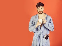 Macho w b??kitnym kontuszu trzyma fili?ank? i magazyn obrazy stock Macho w b??kitnym kontuszu trzyma fili?ank? i magazyn obrazy stock