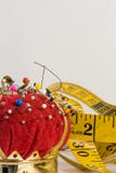 Macro de vintage Pin Cushion avec le fond de mesure de bande et de lumière image libre de droits Macro de vintage Pin Cushion avec le fond de mesure de bande et de lumière image libre de droits