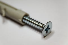 Macroclose-up van chroomschroefdraad en beige pen op witte achtergrond in gedeeltelijke nadruk stock fotografie Macroclose-up van chroomschroefdraad en beige pen op witte achtergrond in gedeeltelijke nadruk stock fotografie