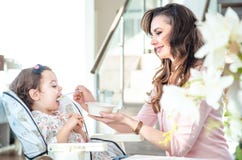 Madre abbastanza giovane che alimenta il suo bambino caro fotografia stock Madre abbastanza giovane che alimenta il suo bambino caro fotografia stock