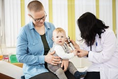 Madre che esamina bambino che è esaminato da medico femminile immagine stock Madre che esamina bambino che è esaminato da medico femminile immagine stock