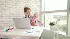 Madre di affari con il telefono cellulare di conversazione del bambino Donna che lavora con il bambino stock footage Madre di affari con il telefono cellulare di conversazione del bambino Donna che lavora con il bambino stock footage