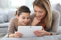 Madre e hija felices que usa la tableta fotografía de archivo libre de regalías Madre e hija felices que usa la tableta fotografía de archivo libre de regalías