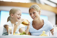 Madre e hija que almuerzan junto en el café fotografía de archivo Madre e hija que almuerzan junto en el café fotografía de archivo