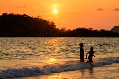 Madre e hija que juegan en la playa en el tiempo de la puesta del sol Imagenes de archivo Madre e hija que juegan en la playa en el tiempo de la puesta del sol Imagenes de archivo