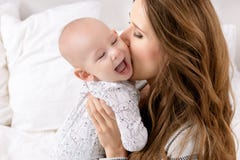 Madre felice che bacia suo figlio adorabile del bambino Famiglia felice Gioco del bambino neonato e della madre fotografia stock Madre felice che bacia suo figlio adorabile del bambino Famiglia felice Gioco del bambino neonato e della madre fotografia stock