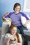 Madre feliz e hija que ven la TV fotos de archivo libres de regalías Madre feliz e hija que ven la TV fotos de archivo libres de regalías