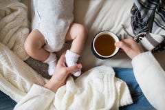 Madre irriconoscibile con il figlio del neonato che si trova sul letto immagine stock libera da diritti Madre irriconoscibile con il figlio del neonato che si trova sul letto immagine stock libera da diritti