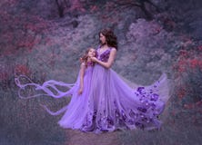 Madre joven atractiva con el pelo ondulado oscuro y su pequeña la hija, uniéndose en el bosque en sorprender largo imagen de archivo libre de regalías Madre joven atractiva con el pelo ondulado oscuro y su pequeña la hija, uniéndose en el bosque en sorprender largo imagen de archivo libre de regalías