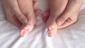 Madre que juega con sus pies del bebé Madre que juega con sus pies del bebé