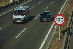 Car and ambulance on highway and SPEED LIMIT sign in Madrid royalty free stock photography Car and ambulance on highway and SPEED LIMIT sign in Madrid royalty free stock photography