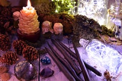Black candles, cones, nature elements and shining bottle on table stock photo Black candles, cones, nature elements and shining bottle on table stock photo