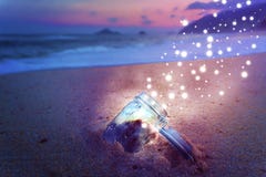 Magical Jar Open On Beach at Night Releasing Star Dust Creative Concept stock photo Magical Jar Open On Beach at Night Releasing Star Dust Creative Concept stock photo