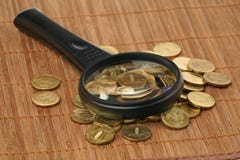 Magnifier And Coins Royalty Free Stock Image