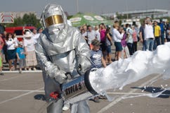 Magnitogorsk, Russland, - August, 7, 2014 Feuerwehrmann setzt heraus ein Feuer in den Marktplatz ein Schutzanzug und Schaum für lizenzfreie stockbilder Magnitogorsk, Russland, - August, 7, 2014 Feuerwehrmann setzt heraus ein Feuer in den Marktplatz ein Schutzanzug und Schaum für lizenzfreie stockbilder