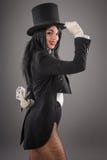 Mago femminile nel vestito dell'esecutore con il Ca magico di gioco e della bacchetta fotografia stock libera da diritti Mago femminile nel vestito dell'esecutore con il Ca magico di gioco e della bacchetta fotografia stock libera da diritti