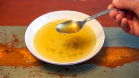 Main avec la cuillère et le plat de la soupe sur la table en bois Photo stock Main avec la cuillère et le plat de la soupe sur la table en bois Photo stock