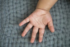 Main de bébé sur un sofa gris photo libre de droits Main de bébé sur un sofa gris photo libre de droits