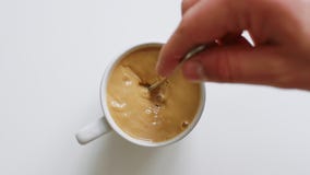 Main de personne remuant le café avec la cuillère banque de vidéos Main de personne remuant le café avec la cuillère banque de vidéos