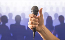 Main tenant le microphone et montrant des pouces photographie stock libre de droits Main tenant le microphone et montrant des pouces photographie stock libre de droits