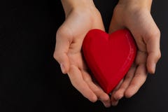 Mains d'un enfant d'adolescent tenant un coeur en bois rouge dans leurs mains photos libres de droits Mains d'un enfant d'adolescent tenant un coeur en bois rouge dans leurs mains photos libres de droits