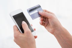 Mains de femme tenant le smartphone et la carte de crédit Images stock Mains de femme tenant le smartphone et la carte de crédit Images stock