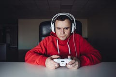 Maison de jeune homme et les jeux de jouer sur la manette Le Gamer joue des jeux d'ordinateur utilisant un gamepad photo libre de droits Maison de jeune homme et les jeux de jouer sur la manette Le Gamer joue des jeux d'ordinateur utilisant un gamepad photo libre de droits