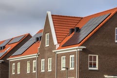 Maisons de rangée modernes avec les tuiles de toit rouges et les panneaux solaires photos stock Maisons de rangée modernes avec les tuiles de toit rouges et les panneaux solaires photos stock
