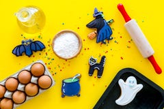 Make halloween gingerbread concept. Icing cookies near rolling pin, baking sheet, eggs, flour on yellow background top stock photography Make halloween gingerbread concept. Icing cookies near rolling pin, baking sheet, eggs, flour on yellow background top stock photography