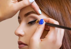 Makeup artist apply makeup and make eye liner with a professional brush in a beauty salon royalty free stock images Makeup artist apply makeup and make eye liner with a professional brush in a beauty salon royalty free stock images