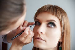 Makeup artist glues false eyelashes Royalty Free Stock Photos Makeup artist glues false eyelashes Royalty Free Stock Photos